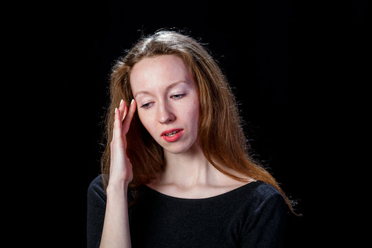 Young brown hair girl with headache on black background