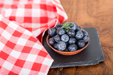  blueberries with fresh mint leaves on wooden cutting board