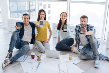 Happy nice people showing you their smartphones