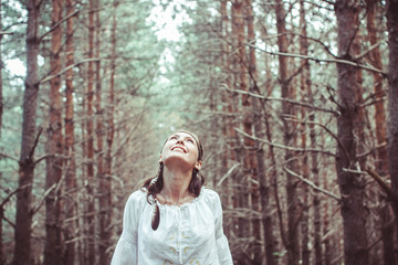 A woman is standing between trees