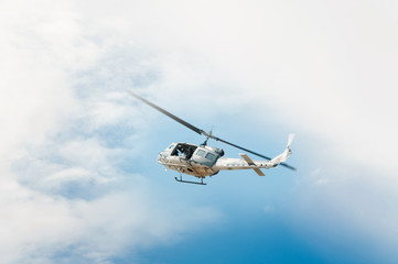 Helicopter in flight, blue sky background
