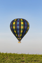 Hot air balloon flying over California winery grape vineyard