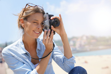 Cheerful girl taking pictures of the beach, tourist area