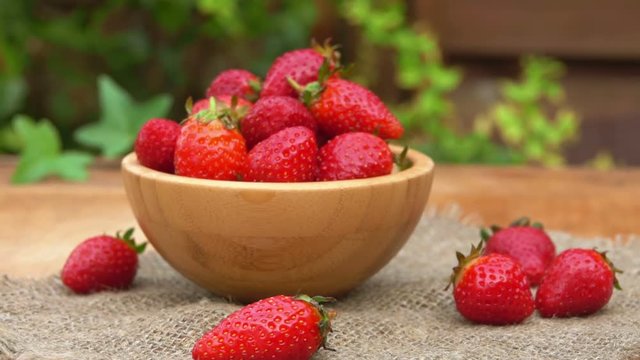 Fresh strawberries in a bowl on a wooden table