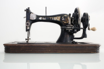 старинная швейная машинка с ручным приводом на белом фоне - obrazy, fototapety, plakaty