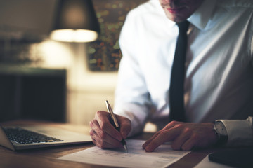 Cropped view of serious businessman signing contract