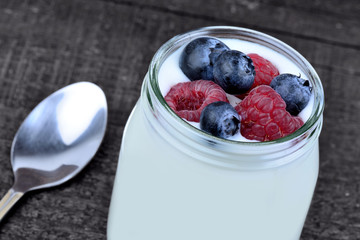 Yogurt with blueberries in a jar glass on table