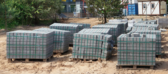 Fototapeta premium Stacks of new concrete paving slabs on wooden pallets.