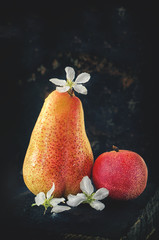 Fruit pear and white peach with small flowers of Apple on a wooden Board close up in low key closeup. © oksanamedvedeva