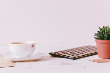 A cup of coffee and keyboard on a white background.