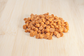 Butterscotch chips on wooden background