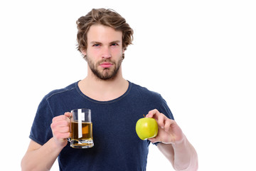 Fototapeta premium Macho man with strong face holding beer and apple