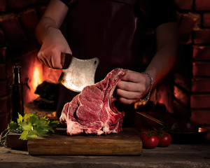 Man cutting raw beef meat.