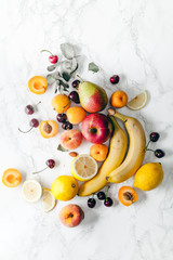 Summer fruits assorted on white marble background. Fresh raw food concept. Copy space