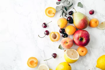 Selbstklebende Fototapeten Summer fruits assorted on white marble background. Fresh raw food concept. Copy space © Anastasiia Nurullina