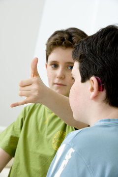Models Do not use for HIV Young boy using the French sign language to discuss with his hearing-impaired brother The French sign language uses signs to designate words but also dactylology (each letter of the alphabet is represented by a defined position of the fingers then enabling to spell a word) and the lip reading The young boy designates the letter \i\ (see image nﾰ0833202 ans series of images from nﾰ0572308 to 0574108 to see the other letters of the alphabet)