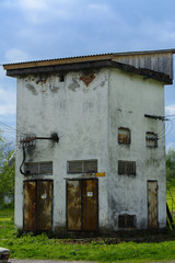 Old electric transformer against the background of a cloudless blue sky. High Voltage Power Distribution Unit