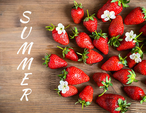 Card with ripe strawberries on wooden background with a text Summer concet Selective focus