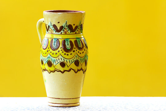 Earthenware figurines, decorative figurines, vase, isolated on a yellow background