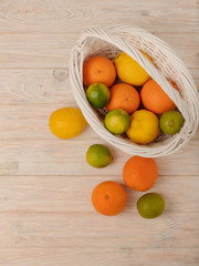 Fototapeta na wymiar Citrus fruits - lemons, oranges and limes on a light wooden background.