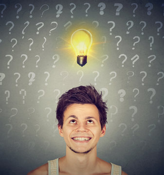 man with idea light bulb and many questions above head