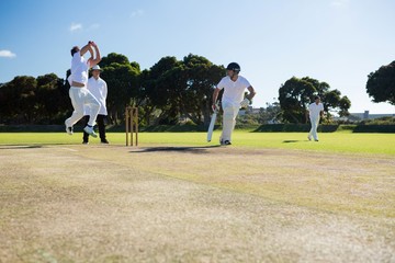 Players playing cricket match at field