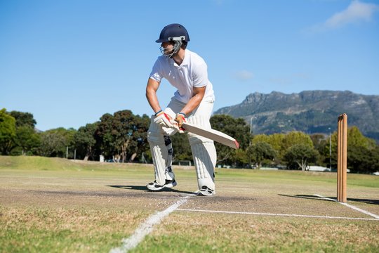 Player batting at field against clear sky
