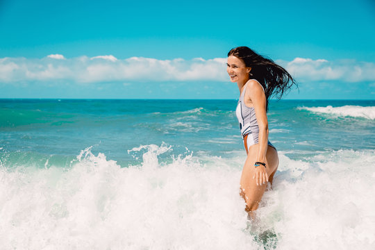 Pretty amazing cheerful young girl in tropical ocean, wearing stylish bikini and long hair