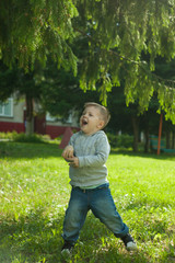 Cute blonde little boy jump in summer park