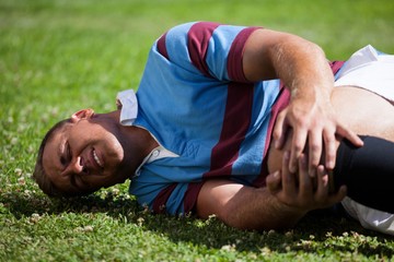 Injuerd young rugby player lying on field - Powered by Adobe