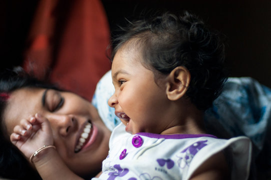 Baby girl sharing cheerful moment with her mother