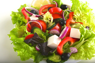 Salad of fresh vegetables and herbs on the table in the plate