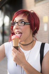 Young woman with ride bike in the city and eats ice cream in summer