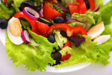 Salad of fresh vegetables and herbs on the table in the plate