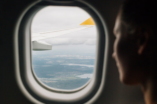 Woman looking through an airplane window