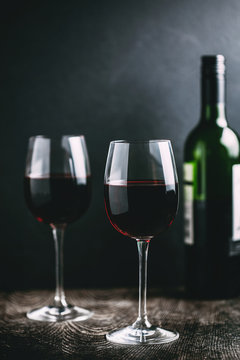 Red wine served in glasses against black background