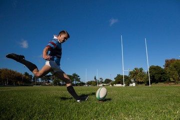 Full length of rugby player kicking ball for goal - obrazy, fototapety, plakaty