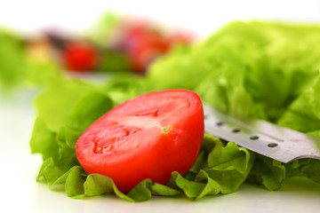 Fresh vegetables with a knife on the table for salad preparation