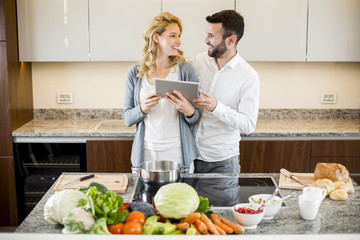 Man helping his girlfriend cooking in modern kitchen