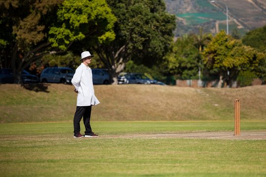 Full length of umpire standing on cricket field