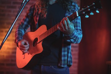 Naklejka premium Mid section of singer playing guitar while singing