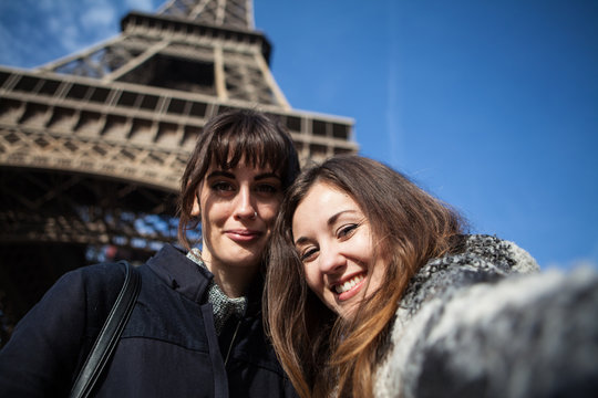Happy young women taking a selfie under the Eiffel tower, Paris