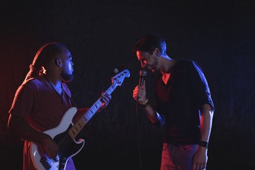 Male singer with guitarist performing at music concert