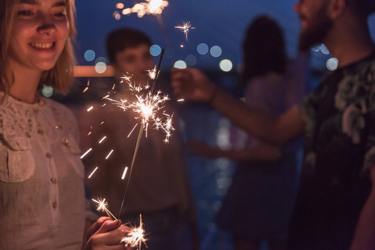 Group of friends celebrating with sparklers 