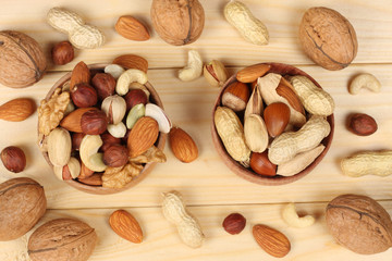 mix almonds, cashew nuts, hazelnut, peanuts, walnuts, pistachio on wooden background. Top view