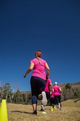 Group of women running through cones in the boot camp