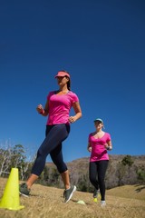Two women running through cones in the boot camp