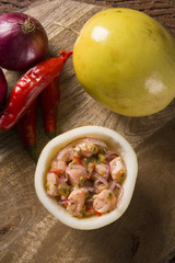 Salmon ceviche with passion fruit sauce on wooden background