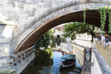 Fototapeta na wymiar Canal of the Moldova river under the last arch of Charles Bridge, Prague.