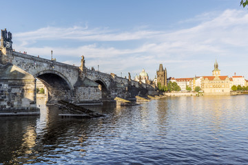 View of the Charles bridge and the Liechtenstein Palace on the Vltava river from the shore of Stare Mesto in Prague